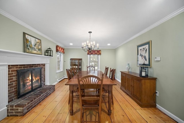 dining space with a baseboard heating unit, baseboards, light wood-style floors, ornamental molding, and a brick fireplace