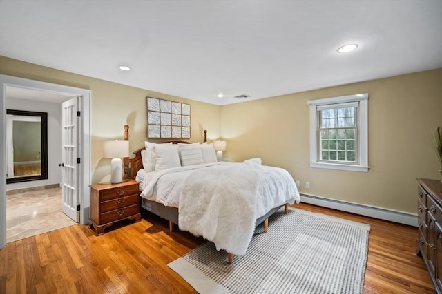 bedroom with recessed lighting, visible vents, light wood finished floors, and baseboard heating