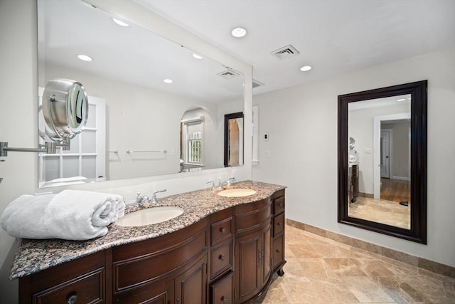 bathroom with double vanity, visible vents, a sink, and recessed lighting