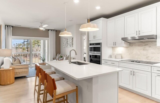 2 Codman Way Unit 311, Westborough, MA 01581 - kitchen featuring a sink, black electric stovetop, double oven, backsplash, and under cabinet range hood