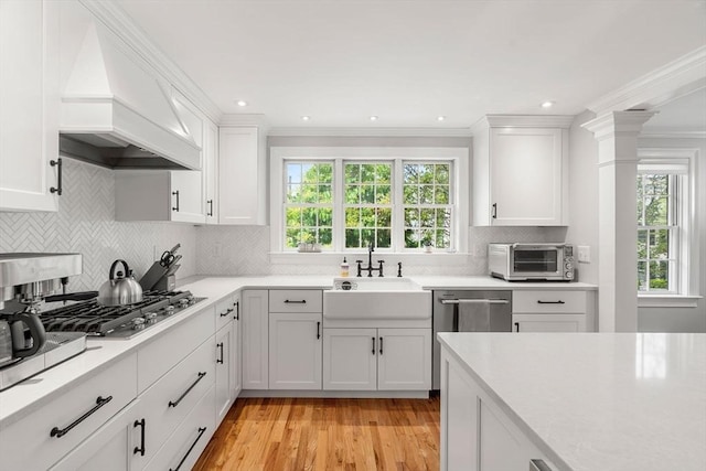 37-1/2 Federal St, Newburyport, MA 01950 - kitchen with custom range hood, appliances with stainless steel finishes, a sink, light countertops, and white cabinetry