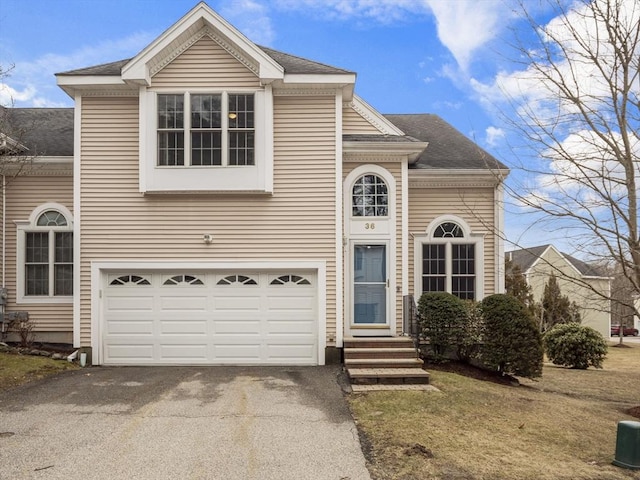 view of front of house with a garage, aphalt driveway, roof with shingles, and entry steps