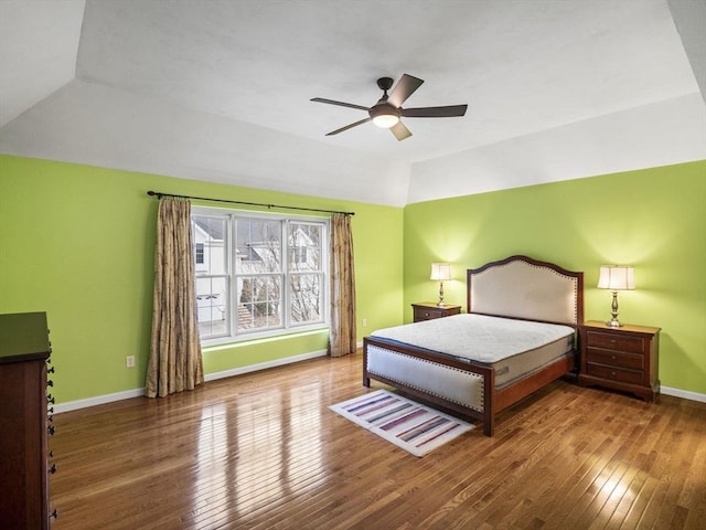 bedroom featuring a ceiling fan, lofted ceiling, baseboards, and hardwood / wood-style floors