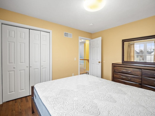 bedroom with dark wood-type flooring, a closet, and visible vents