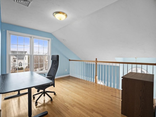 office area featuring lofted ceiling, visible vents, baseboards, and wood finished floors