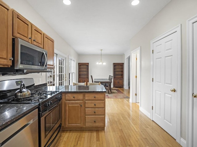 kitchen featuring brown cabinets, a peninsula, stainless steel appliances, light wood-style floors, and recessed lighting