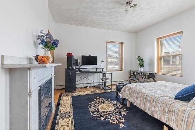 21 Parker St, Boston, MA 02129 - bedroom featuring wood finished floors, baseboard heating, a textured ceiling, and a fireplace