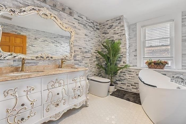 21 Parker St, Boston, MA 02129 - full bathroom with a freestanding tub, tile walls, double vanity, toilet, and tile patterned floors