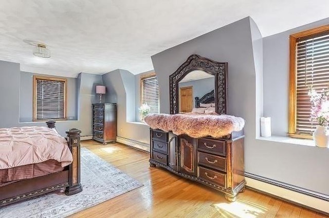 21 Parker St, Boston, MA 02129 - bedroom featuring a baseboard radiator, light wood-type flooring, and baseboards