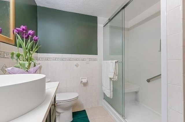 21 Parker St, Boston, MA 02129 - bathroom featuring tile walls, a shower stall, a wainscoted wall, vanity, and tile patterned floors
