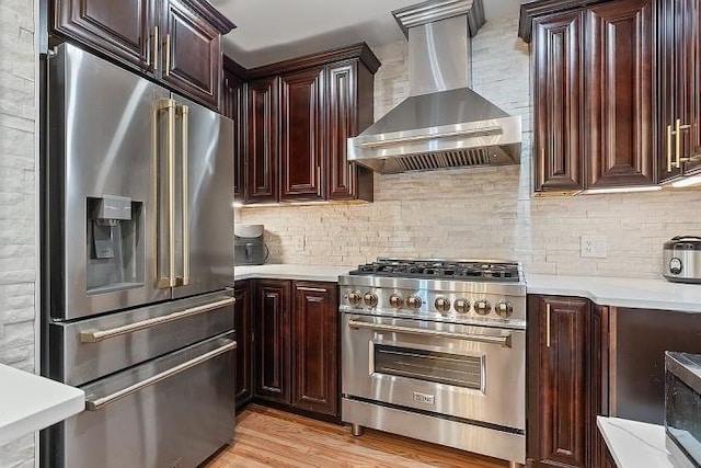 21 Parker St, Boston, MA 02129 - kitchen featuring high quality appliances, wall chimney range hood, light countertops, and tasteful backsplash