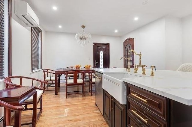 21 Parker St, Boston, MA 02129 - kitchen with a wall mounted AC, stainless steel dishwasher, light wood finished floors, a center island with sink, and recessed lighting