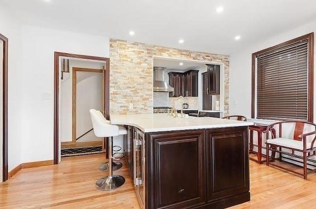 21 Parker St, Boston, MA 02129 - kitchen featuring wall chimney range hood, light countertops, light wood-style floors, dark brown cabinets, and recessed lighting