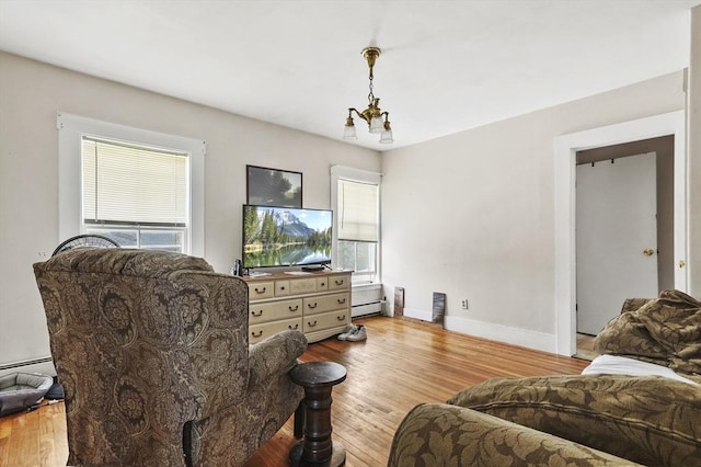 living area featuring baseboards, wood finished floors, and a baseboard radiator