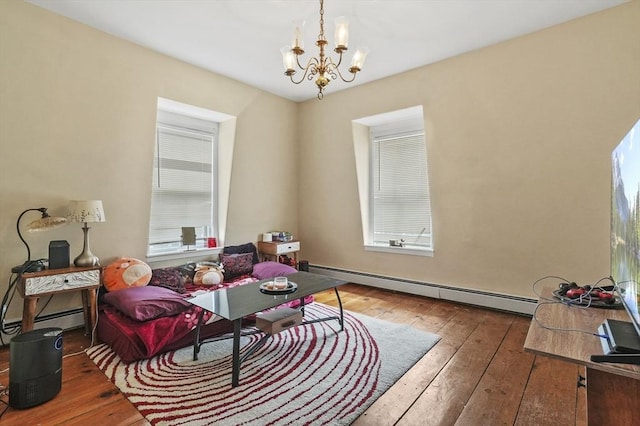 sitting room featuring a baseboard radiator, plenty of natural light, and wood-type flooring