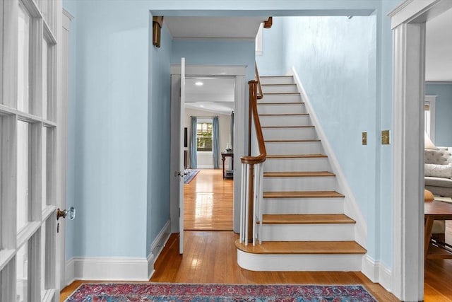 stairway featuring wood finished floors and baseboards