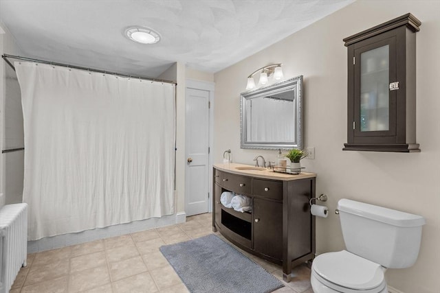 full bathroom featuring radiator, toilet, vanity, and tile patterned floors