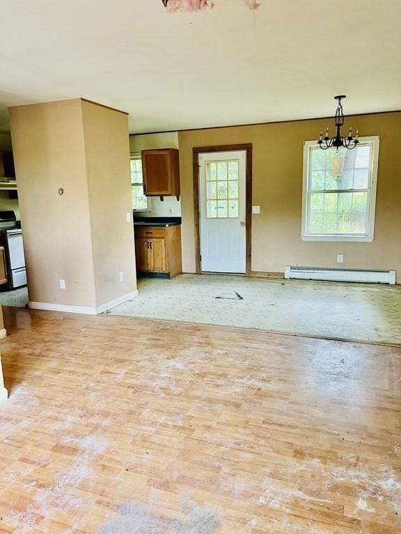 unfurnished living room featuring baseboards, a baseboard heating unit, and a chandelier