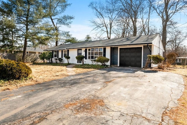 single story home featuring driveway, an attached garage, and fence