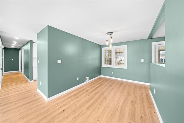 interior space with visible vents, light wood-style flooring, and baseboards