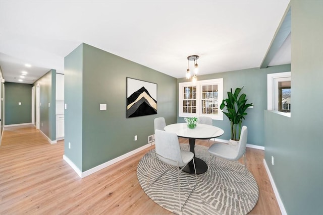 dining room with light wood-type flooring, baseboards, and visible vents