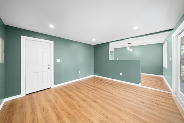 empty room featuring recessed lighting, baseboards, and light wood-style floors