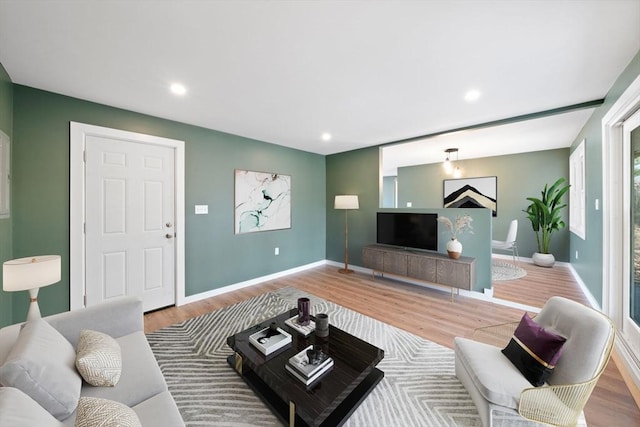 living area featuring recessed lighting, baseboards, and wood finished floors