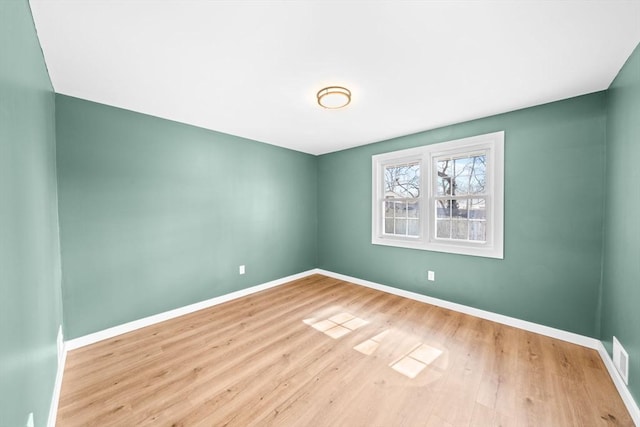 unfurnished room with visible vents, baseboards, and wood finished floors