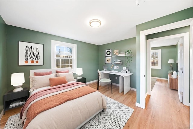 bedroom with baseboards and light wood finished floors