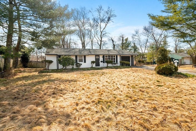 ranch-style home featuring a garage and fence