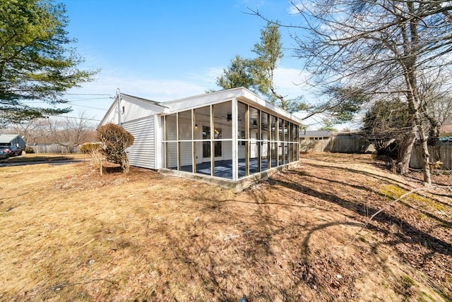 rear view of property featuring a sunroom