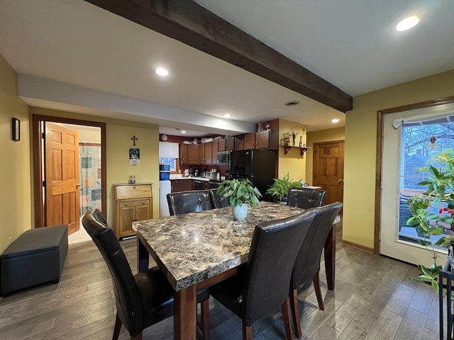 dining room featuring hardwood / wood-style floors and beam ceiling