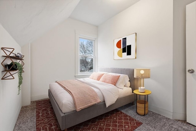 bedroom with dark colored carpet and lofted ceiling