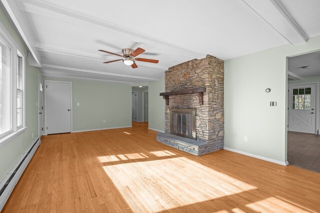 unfurnished living room featuring beam ceiling, a healthy amount of sunlight, a baseboard radiator, and hardwood / wood-style flooring