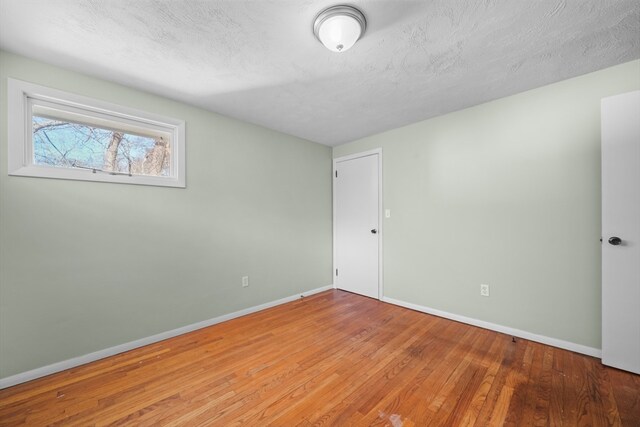 spare room featuring hardwood / wood-style floors and a textured ceiling