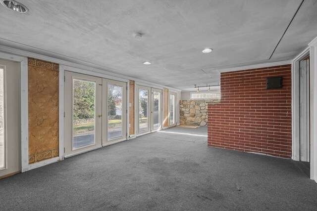 unfurnished room featuring carpet, a textured ceiling, and ornamental molding