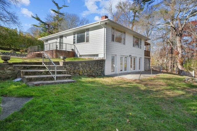 back of property featuring a lawn, a patio area, and a wooden deck