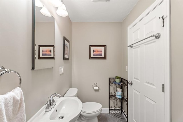 63 Prospect St Unit 2, Woburn, MA 01801 - bathroom featuring toilet, tile patterned floors, baseboards, and a sink