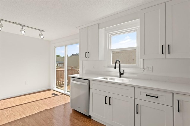 126 Willard St Unit D, Lowell, MA 01850 - kitchen with dishwasher, a sink, track lighting, light countertops, and a textured ceiling