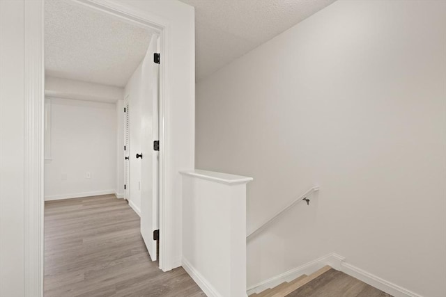 126 Willard St Unit D, Lowell, MA 01850 - corridor with an upstairs landing, a textured ceiling, wood finished floors, and baseboards