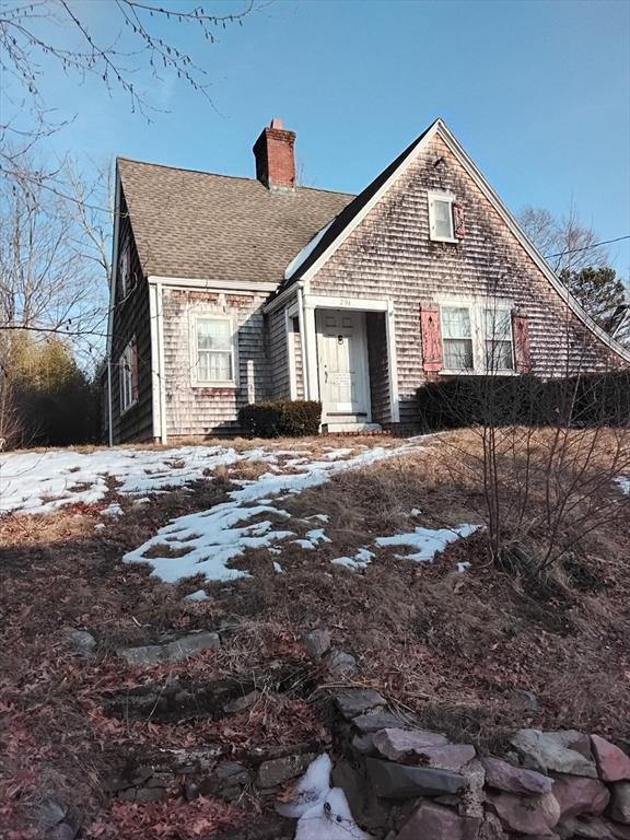 view of front of house featuring a shingled roof and a chimney