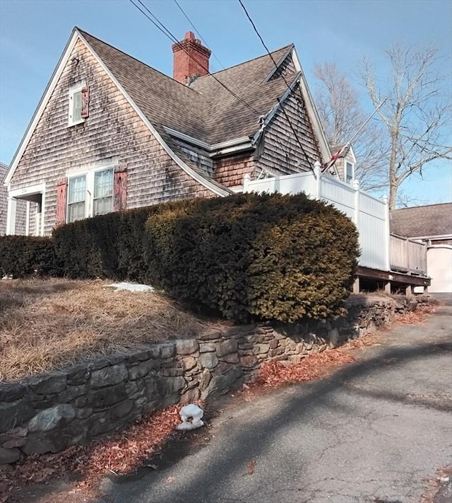 view of property exterior with roof with shingles