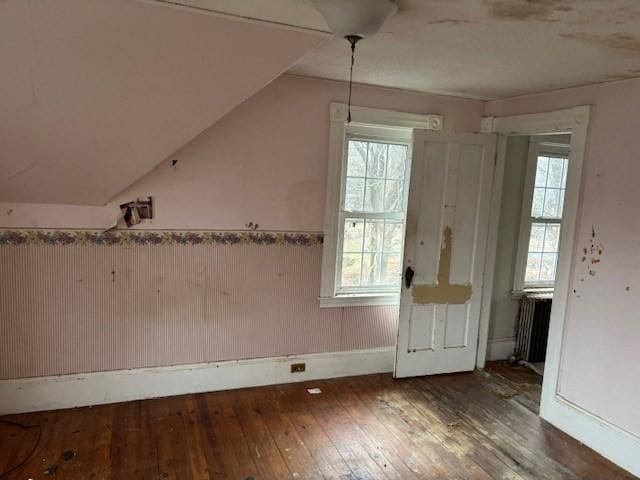 bonus room featuring dark hardwood / wood-style flooring, radiator heating unit, and vaulted ceiling