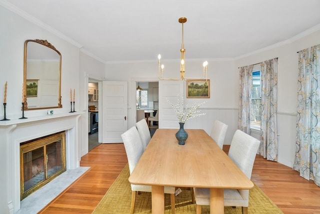 dining space featuring light wood-type flooring, a wealth of natural light, and crown molding