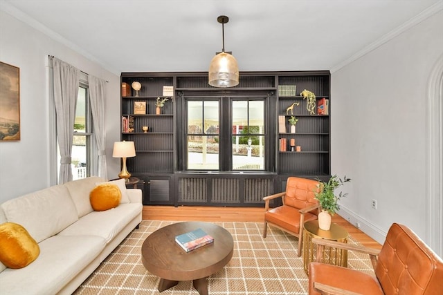 living area with plenty of natural light, wood-type flooring, ornamental molding, and radiator heating unit