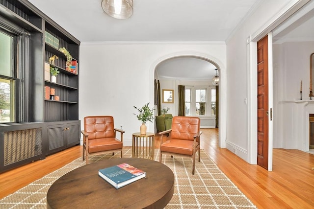 living area with hardwood / wood-style flooring and crown molding