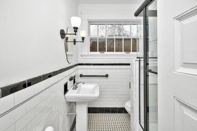 bathroom with toilet, ornamental molding, and tile walls