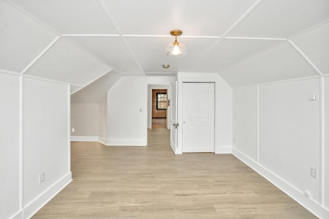 bonus room with light hardwood / wood-style floors and lofted ceiling