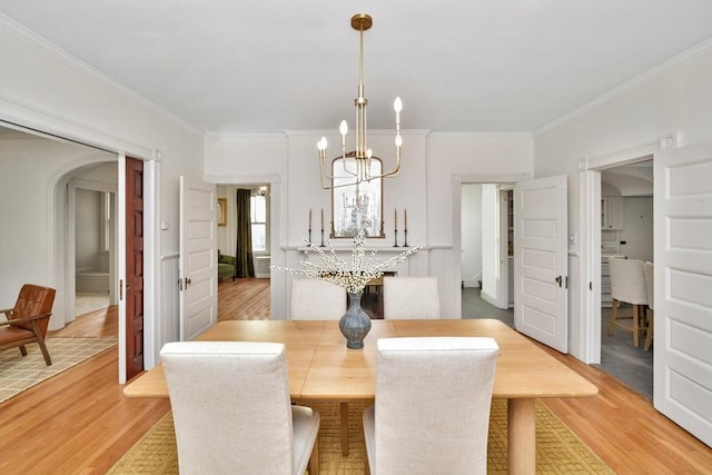 dining space featuring a chandelier, light hardwood / wood-style floors, and crown molding