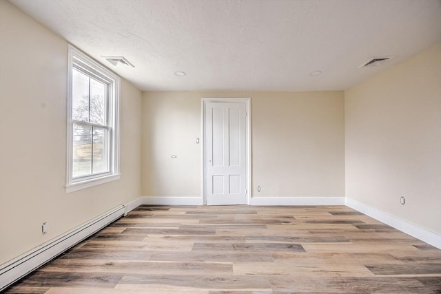 6 Nemasket St, Middleboro, MA 02346 - spare room featuring visible vents, baseboards, light wood-style floors, a textured ceiling, and baseboard heating